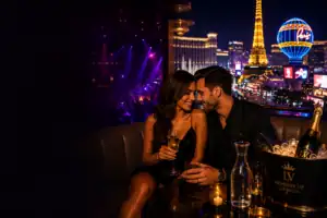 Couple seated together in a luxury Las Vegas nightlife setting with the Strip visible
